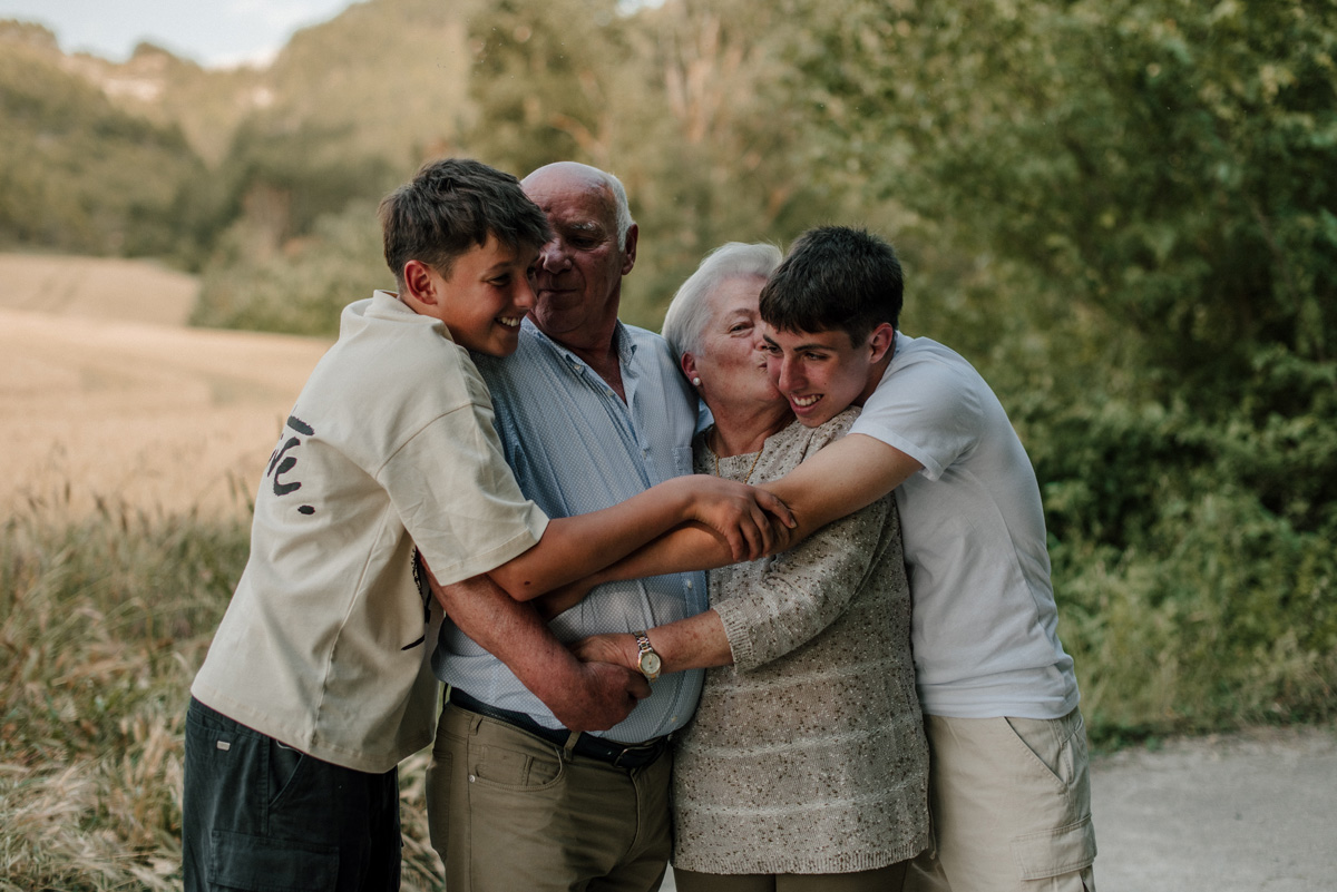 Fotografía familiar en Navarra, abuelos abrazados por sus nietos durante una sesión emocional de Pía Alvero.