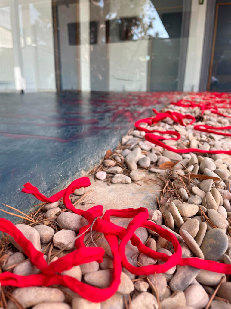 Cordones rojos y tarjetas de la exposición Referentes de Pía Alvero, proyecto sobre mujeres profesionales e igualdad.