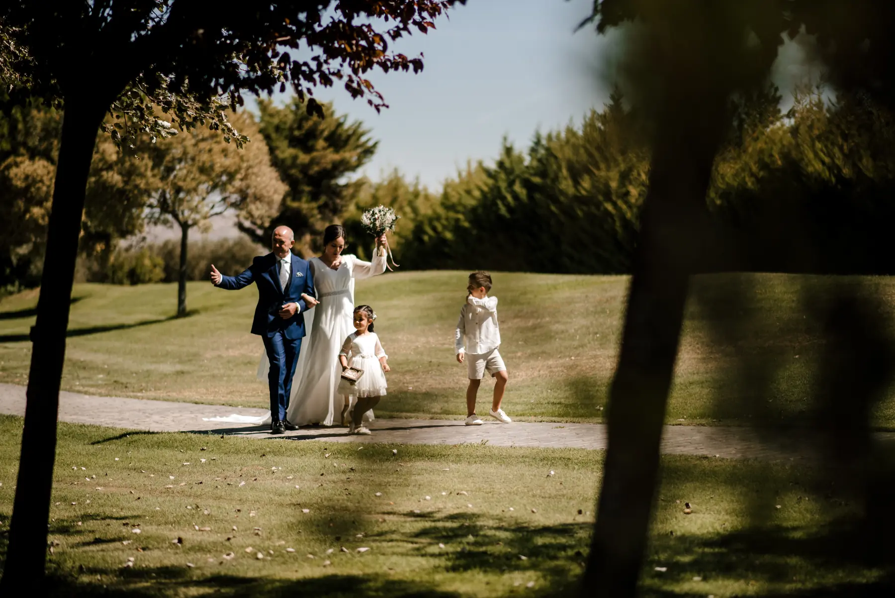 Pareja recién casada caminando con sus hijos después de la ceremonia
