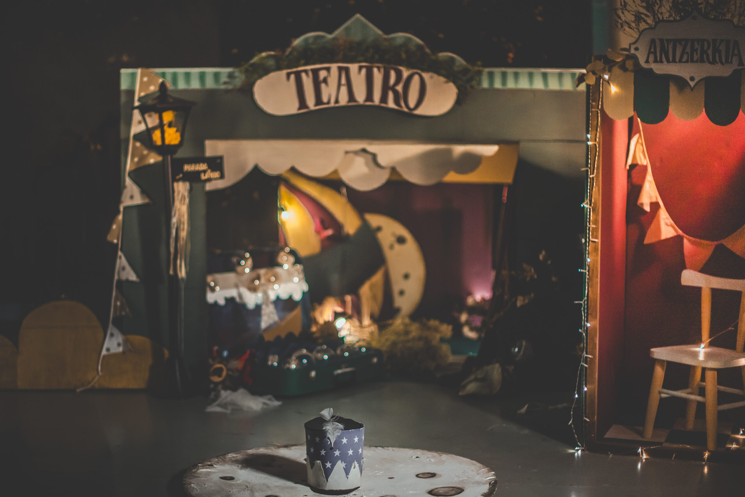 Escenario de teatro con luna, luces y objetos decorativos