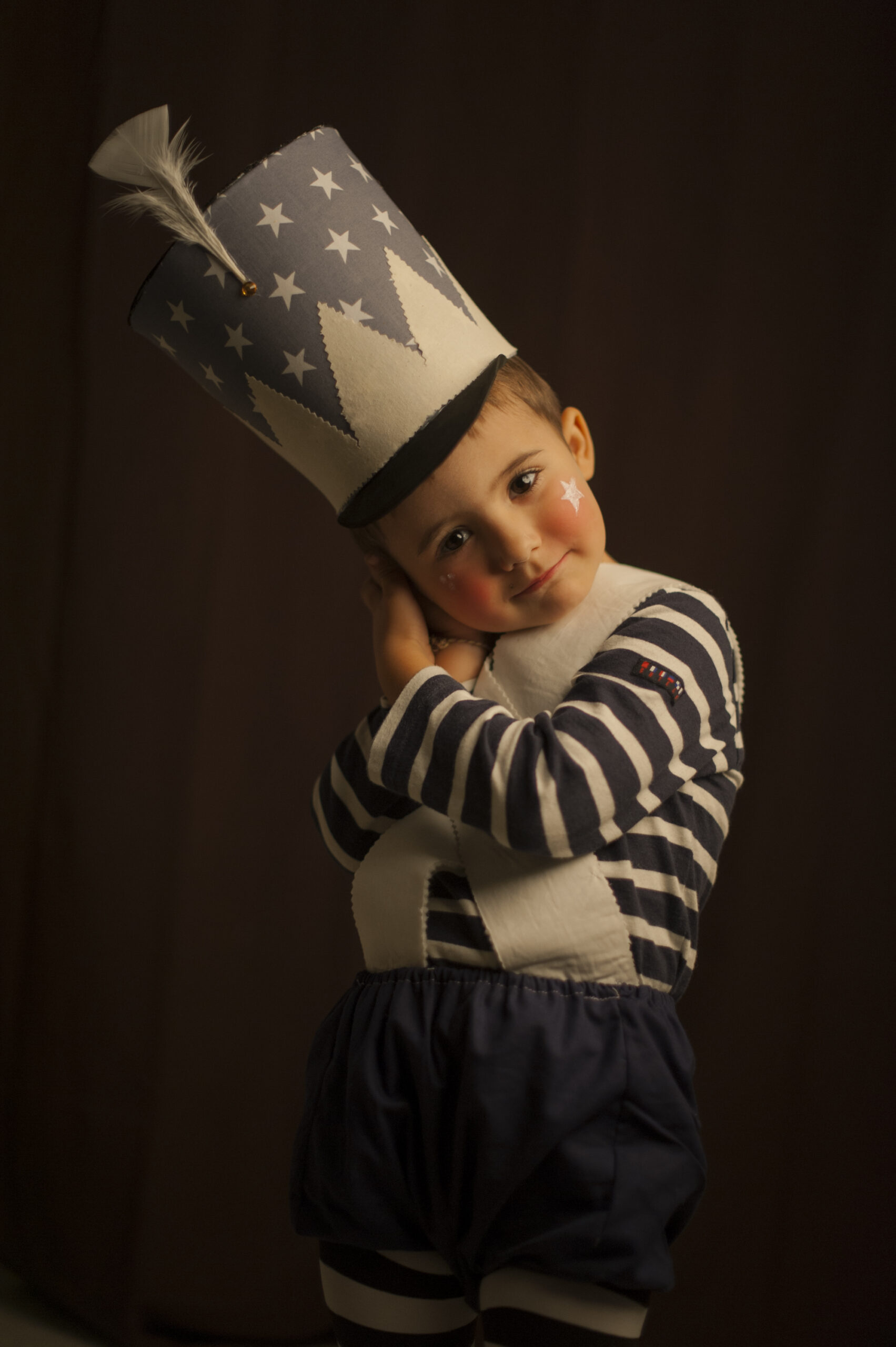 Niño con un sombrero de estrellas y ropa de rayas